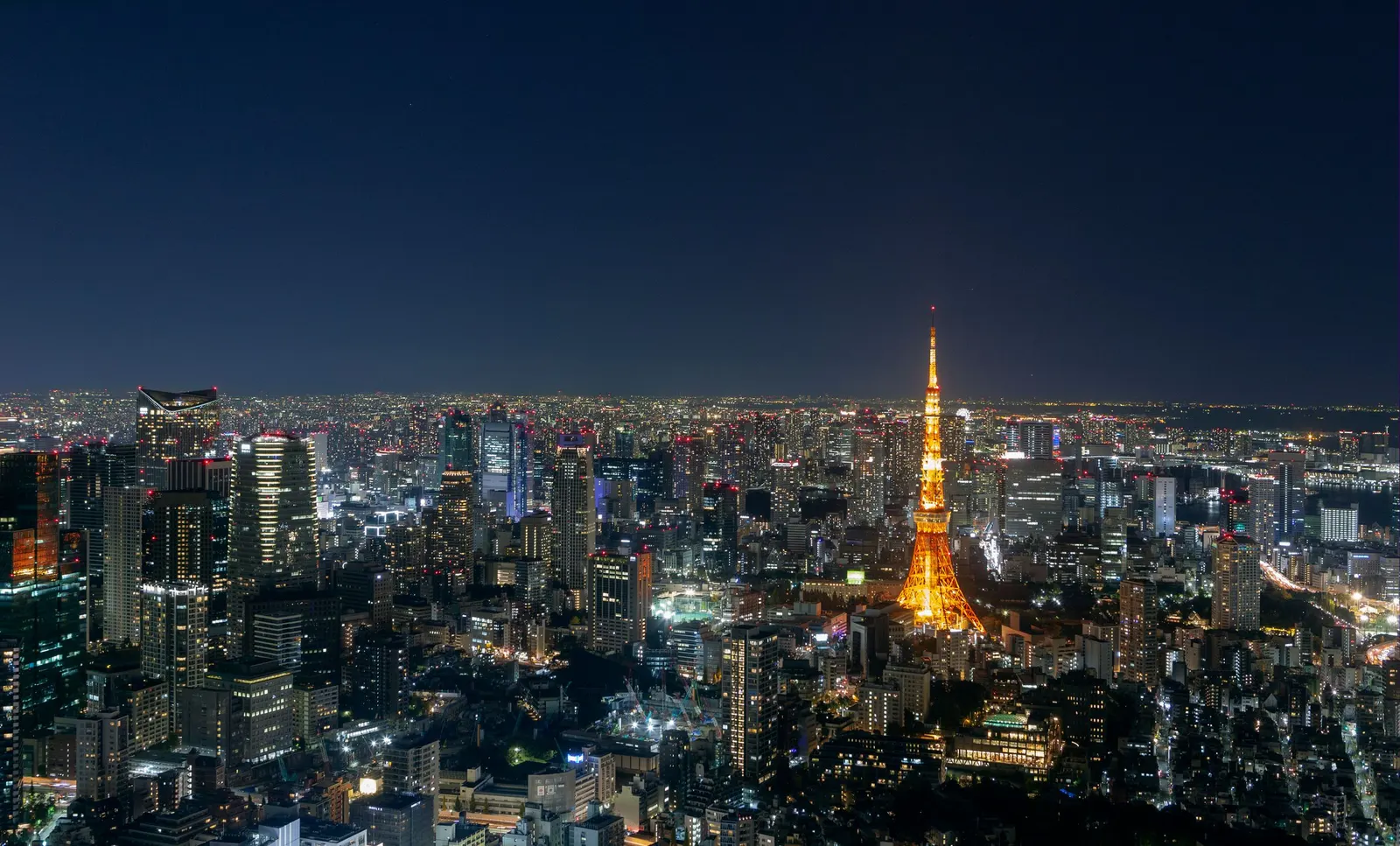 Tokyo at night, with Tokyo Tower lit among the towers of the city