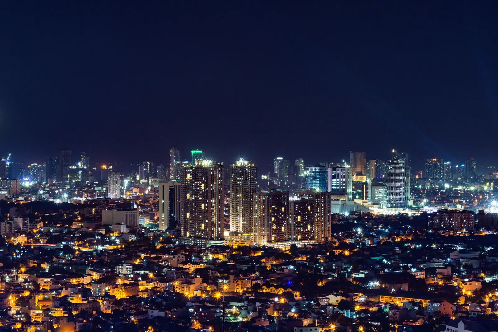 Manila lit at night, seen across the city